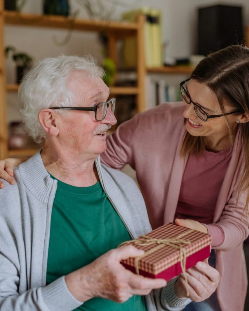 happy-woman-surprising-her-senior-father-when-visiting-him-at-home-and-bringing-present-
